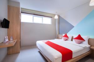 a bedroom with a large bed with red pillows at Flagship 101 Apple Platinum in Jakarta