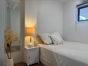a bedroom with a bed with a lamp and a mirror at Haven39 in Bayview Heights +1 photo