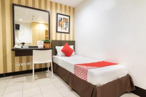 a hotel room with a bed and a desk at Orange Nest Hotel in Manila