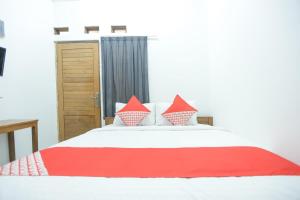 a bedroom with a bed with red and white pillows at Hotel O near Bundaran HI formerly Harmoni Residence in Jakarta
