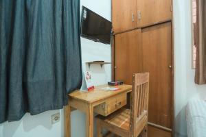 a bedroom with a desk with a television and a bed at Hotel O near Bundaran HI formerly Harmoni Residence in Jakarta