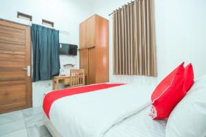 a bedroom with a large bed with red pillows at Hotel O near Bundaran HI formerly Harmoni Residence in Jakarta