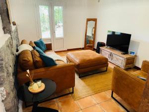 a living room with a couch and a television at LaKaz à Eva in Cilaos