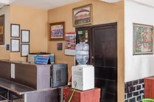 a room with a cash register and a bottle of water at Hotel O Ilir Barar I Near Rumah Sakit Islam Siti Khadijah Formerly Maleo Hotel in Palembang