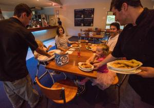 a group of people sitting around a table eating food at Settlers Inn in Port Macquarie +14 photos