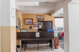 a restaurant with a large wooden table in a room at Hotel O Ilir Barar I Near Rumah Sakit Islam Siti Khadijah Formerly Maleo Hotel in Palembang