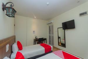 a hotel room with a bed and a flat screen tv at Hotel O The Vintage Hotel in Nusajaya