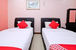 Postel nebo postele na pokoji v ubytování OYO 714 Arina Hotel