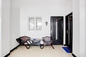 a patio with two chairs and a table in a room at Hotel O Pondok Helomi in Yogyakarta