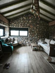 a living room with a couch and a stone wall at Stone House Montenegro in Danilovgrad
