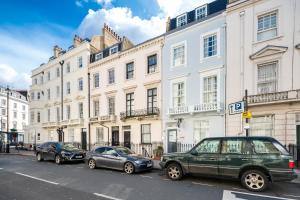 three cars parked on a street in front of buildings at OYO Bakers Hotel London Victoria in London