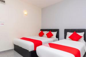 two beds in a room with red and white pillows at Muar City Hotel in Muar +28 photos