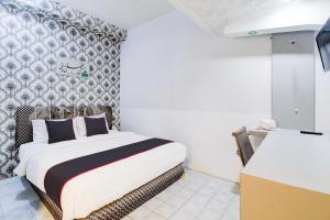 Postel nebo postele na pokoji v ubytování Hotel O Jalan Jenderal Sudirman Near Imam Bonjol Square