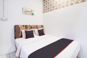 Postel nebo postele na pokoji v ubytování Hotel O Jalan Jenderal Sudirman Near Imam Bonjol Square