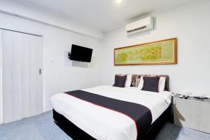 Postel nebo postele na pokoji v ubytování Hotel O Jalan Jenderal Sudirman Near Imam Bonjol Square
