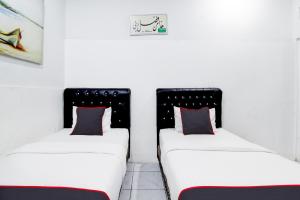 Postel nebo postele na pokoji v ubytování Hotel O Jalan Jenderal Sudirman Near Imam Bonjol Square