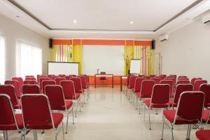 a lecture room with red chairs and a whiteboard at Hotel O Banguntapan Near Galaxy Waterpark Formerly Hotel Desa Puri in Yogyakarta +29 photos