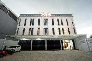 KeputihSuper OYO Capital O 449 The Colins的一栋白色建筑，前面停着一辆汽车
