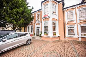 a silver car parked in front of a building at Arinza Hotel, London Ilford in Ilford