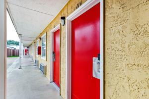 a red door on the side of a building at OYO Hotel San Antonio Lackland near Seaworld in San Antonio +33 photos