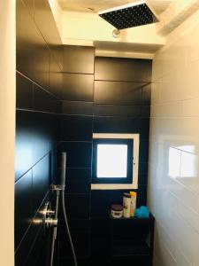 a bathroom with a black tiled wall and a window at Casa Torre San Lorenzo in Pisa