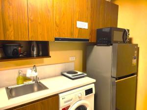 a small kitchen with a sink and a refrigerator at Timbi Suites Mactan in Lapu Lapu City