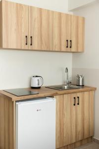 une cuisine avec des armoires en bois et un évier dans l'établissement Nexus Apartments, à Thessalonique 40 autres photos