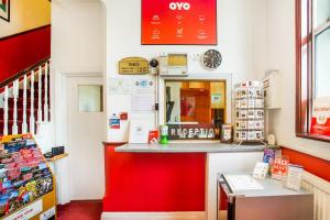 a shop with a red counter in a store at London Guest House by OYO - Acton in London