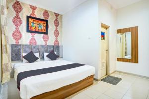 a bedroom with a large bed in a room at Hotel O Padang City Center Near Pantai Padang Formerly D'Dhave Hotel in Padang