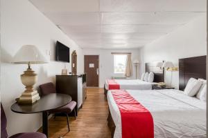 a hotel room with two beds and a table at OYO Hotel San Antonio Lackland Air Force Base West in San Antonio