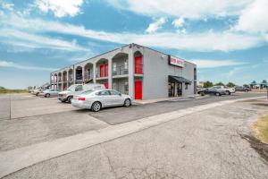 a building with cars parked in a parking lot at OYO Hotel San Antonio Lackland Air Force Base West in San Antonio