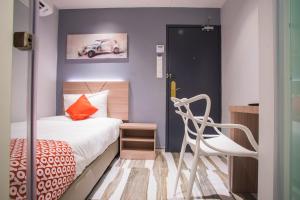 a small bedroom with a bed and a chair at Hotel O Gs Hotels Near Strand Mall in Kota Damansara