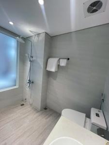 a white bathroom with a shower and a toilet at Đức Dương Hotel in Kinh Môn