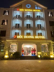 a large building with a dog driving hotel at night at Đức Dương Hotel in Kinh Môn