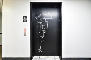 a black elevator door with a drawing of a man and a woman at OYO Townhouse Inn Jacksonville near Little Rock Air Force Base in Jacksonville +47 photos
