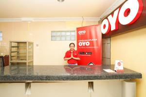 a woman standing in front of a gas station at Super OYO Capital O 1086 '2oscar in Surabaya