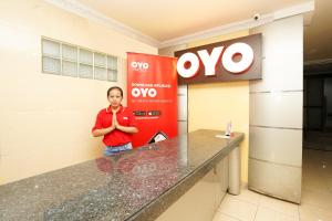 a woman standing in front of a oco gas station at Super OYO Capital O 1086 '2oscar in Surabaya