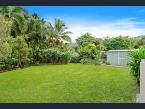 a yard with a green lawn with trees and a building at Haven39 in Bayview Heights