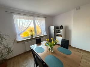 a dining room with a table and chairs and a refrigerator at Zacisze u Rysia in Brochów