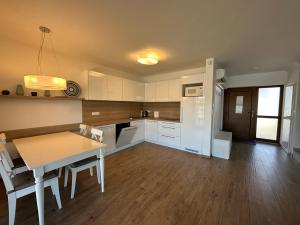a kitchen with a table and a dining room at Lake house 630 in Šajdíkove Humence