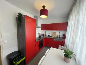 una cucina con armadi rossi e tavolo bianco di Charmantes Familienrefugium im Zentrum von Ludwigshafen - Eleganz & Komfort Ideal fur Familien a Ludwigshafen am Rhein