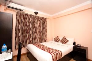 una camera d'albergo con letto e tenda di Kathmandu City Hotel a Kathmandu