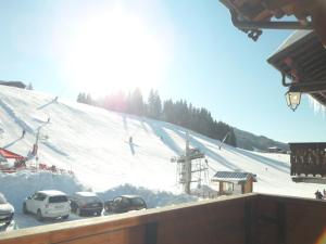 a ski slope with cars parked next to a ski lift at Chalet Hôtel Aiguille Blanche Logis in Les Gets