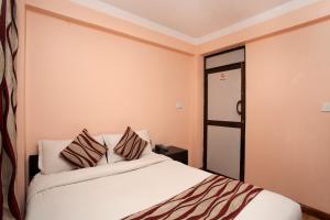 una camera con un letto bianco con due cuscini di Kathmandu City Hotel a Kathmandu