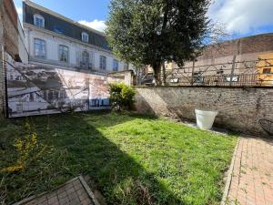 a yard with a brick wall and a building at Les Chartriers D&G in Mons