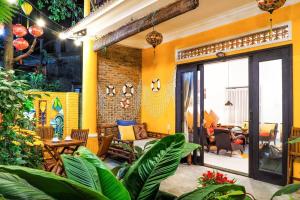 una sala de estar con paredes y plantas amarillas en Hoi An Villa near An Bang Beach, en An Bàn (2)