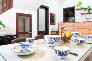una mesa con platos azules y blancos. en Hoi An Villa near An Bang Beach, en An Bàn (2)