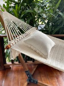 una sedia di vimini seduta su un portico con piante di Boutique Beach Cottage - Steps to Beach a Nathon Bay Altre 14 foto