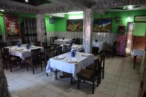 a dining room with tables and chairs and green walls at hotel trehans in Sarāhan