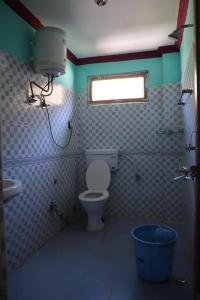 a bathroom with a toilet and a sink and a window at hotel trehans in Sarāhan